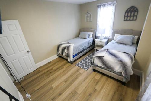 1 dormitorio con 2 camas y suelo de madera en Cozy Modern 3 bedroom Home in west Philly en Filadelfia