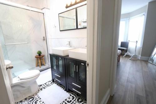 a bathroom with a sink and a toilet and a mirror at Cozy Modern 3 bedroom Home in west Philly in Philadelphia
