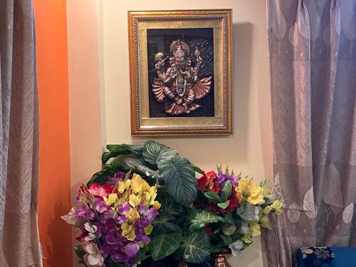 a picture of a painting on a wall with flowers at Sacred Trails Homestay in Burhānilkantha