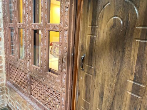 an old wooden door with a window in a room at Sacred Trails Homestay in Burhānilkantha