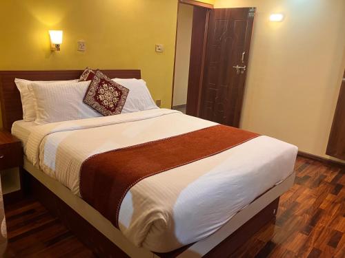 a bedroom with a large bed and a bathroom at Sacred Trails Homestay in Burhānilkantha