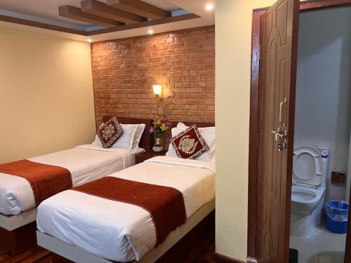Habitación de hotel con 2 camas y aseo en Sacred Trails Homestay, en Burhānilkantha