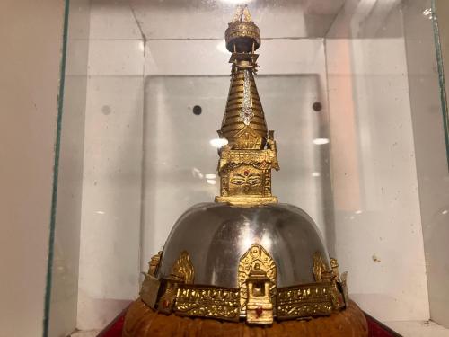 a gold and black helmet on display in a glass case at Sacred Trails Homestay in Burhānilkantha