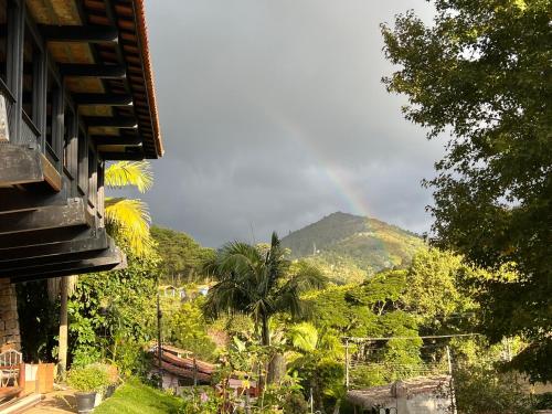 a view of a mountain with a rainbow in the sky at Casa Holanda - Suite Austria c jacuzzi in Teresópolis