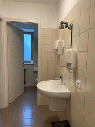 uma casa de banho com um lavatório e um espelho em HostHello Nus em Nus