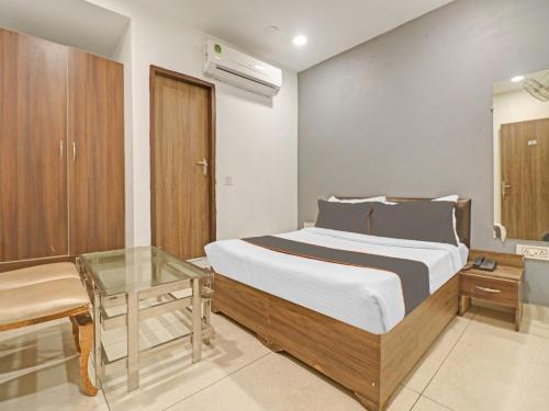 a bedroom with a bed and a glass table at HOTEL Seven Heaven -Lawrence Road New Delhi in New Delhi