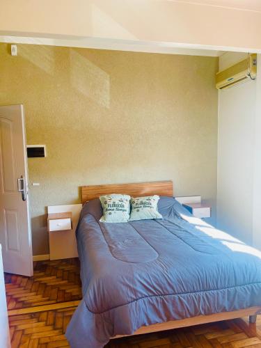 een slaapkamer met een blauw bed met 2 kussens bij Ana Rent II in Boulogne