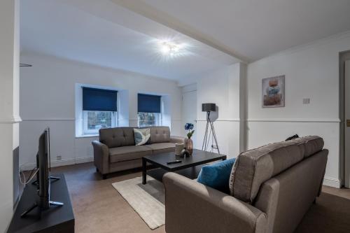 uma sala de estar com dois sofás e uma televisão em The Wilton em Glasgow