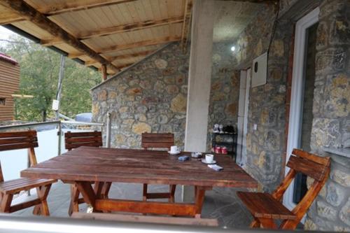 einen Holztisch und Stühle auf einer Terrasse in der Unterkunft Villa Giti in Boge