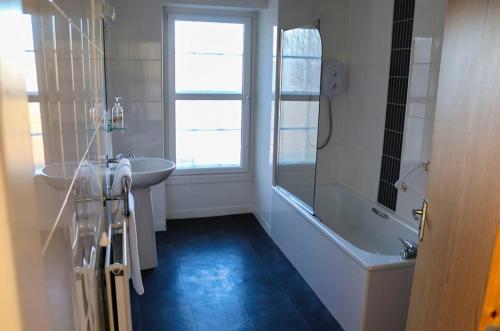 a bathroom with a sink and a tub and a shower at Royal Hotel in Forfar