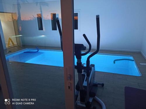 a gym with a swimming pool in the background at Bienvenu chez VillAtlas in Marrakech