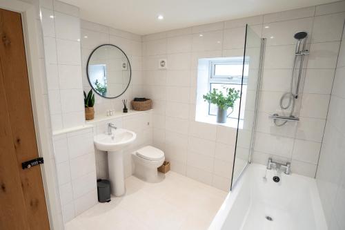 a bathroom with a toilet and a tub and a sink at 3 Brooke Terrace in Medbourne