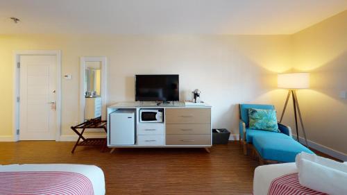 a living room with a tv and a blue couch at The Hotel Maria in Westerly