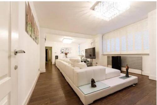 a white living room with a large white couch at Super large apartment in London for larger groups in London