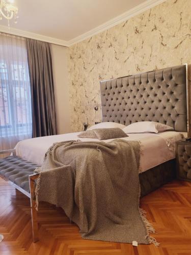 a bedroom with a large bed with a large headboard at Fancy Flats in Sibiu