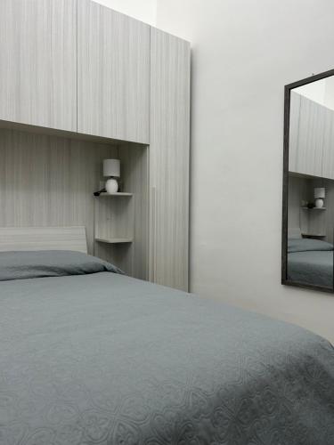 una camera con un grande letto e uno specchio di Ciuri Holiday a Trapani