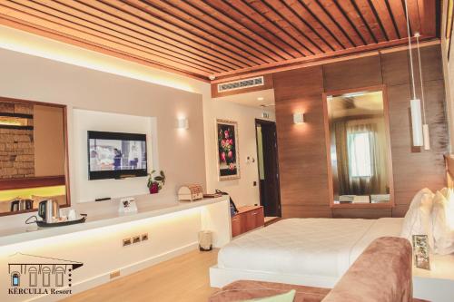 a large bedroom with a bed and a desk at KERCULLA Resort in Gjirokastër