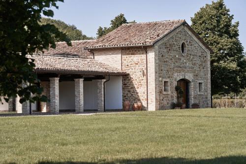 a large stone building with a grass yard at Borgo Lanciano in Castelraimondo