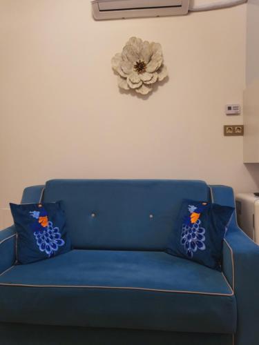 a blue couch in a living room with a flower on the wall at Fancy Flats in Sibiu