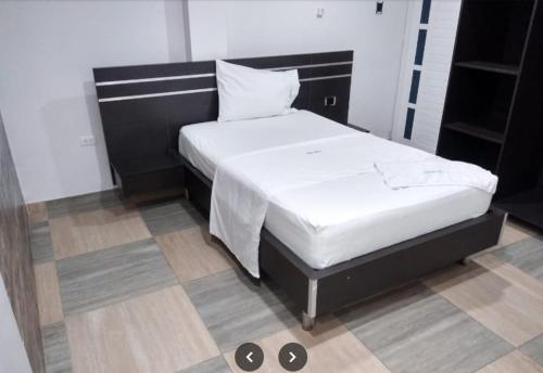 1 dormitorio con 1 cama con cabecero negro en Hotel Sharey, 