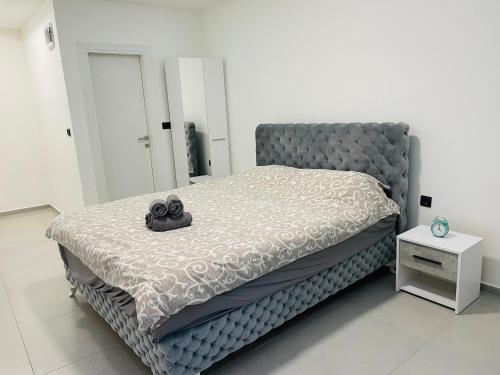 Luxury Centar في أراندجيلوفاك: غرفة نوم مع سرير كبير مع اللوح الأمامي رمادي