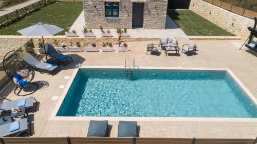 an overhead view of a swimming pool with chairs and an umbrella at Sirena Villa in Chania