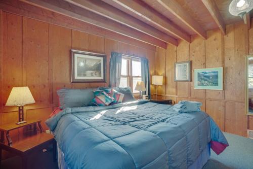 a bedroom with a large bed in a room with wooden walls at Red Feather Lakes Cabin with Deck and Views! in Red Feather Lakes