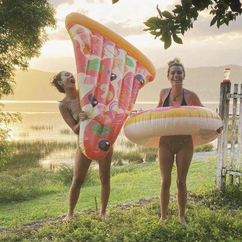 two women in bathing suits standing with surfboards at Bikini Beach in El Remate