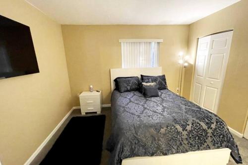 a bedroom with a bed with black pillows on it at Luxury Miami 2br Townhouse Near Stadium !! in Miami Gardens