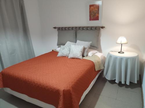 1 dormitorio con 1 cama y 1 mesa con lámpara en La casita de mi infancia en Mendoza
