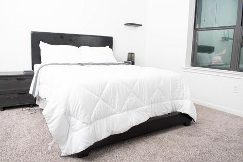 1 cama blanca en un dormitorio con ventana en Midtown Contemporary Luxury 1BD-Pool-Gym-Patio-Office, en Houston