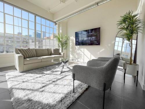 a living room with a couch and a tv at Modern Loft in DTLA - Rooftop Pool & Free Parking! in Los Angeles