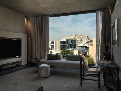 a living room with a couch and a large window at Monastik Living in Athina in Athens