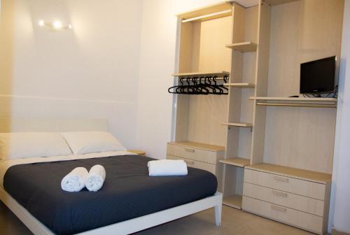 a bedroom with a bed with white shoes on it at Home Rent Mancini in Rome
