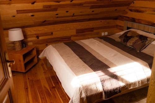 a bedroom with a bed in a log cabin at Rajska koliba in Kaludjerske Bare