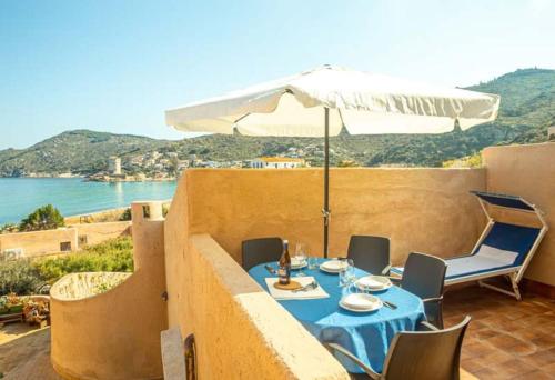 a blue table with an umbrella on a balcony at Fortuna in Campese