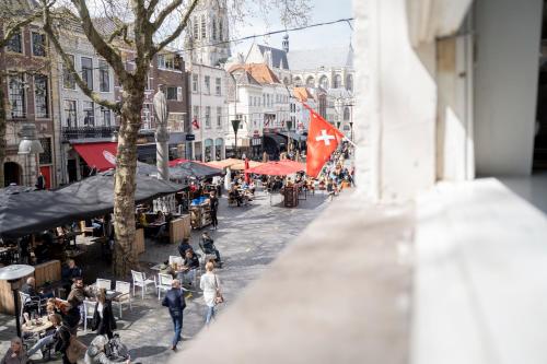 uma vista para uma rua da cidade com pessoas e cafés em Gloria's loft op de Grote Markt em Breda