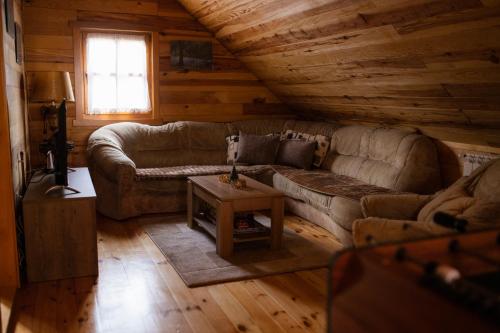 a living room with a couch and a table at Rajska koliba in Kaludjerske Bare