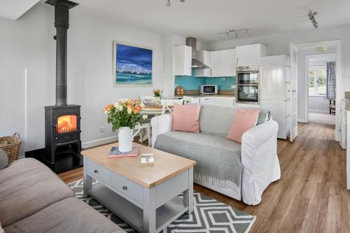 a living room with a couch and a stove at Garden flat near Goodwood with stunning views in Petersfield