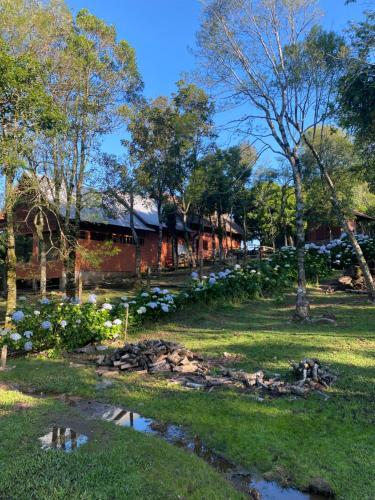 ein Haus mit einem Teich davor in der Unterkunft Casa de campo próximo a Gramado in Três Coroas