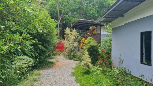 a garden path next to a white house at Koh Mak Littel House in Ko Mak