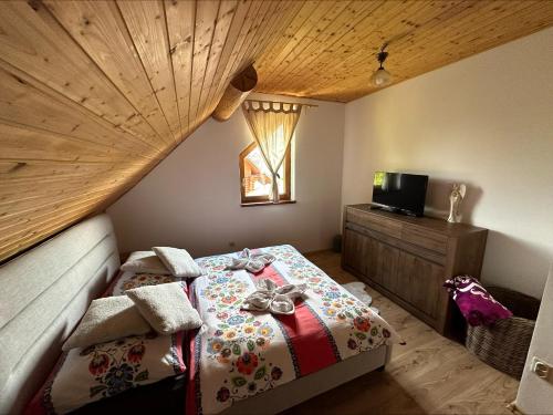 a bedroom with a bed with a wooden ceiling at Zrub Vlašky in Bešeňová
