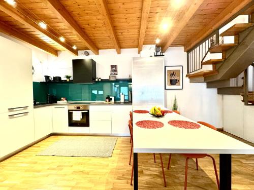 una cocina con una mesa blanca y algunas sillas en The Loft, en Timisoara