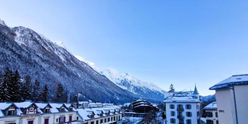 une ville couverte de neige devant une montagne dans l'établissement Appartement Chamonix Centre Vue MontBlanc, à Chamonix-Mont-Blanc