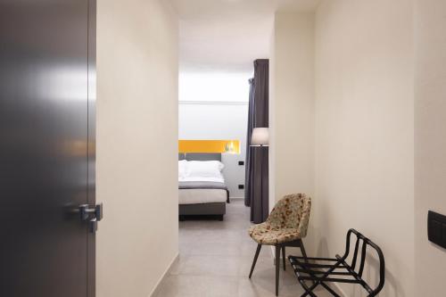 a bedroom with a bed and a chair in a room at Amiata Suite in Abbadia San Salvatore