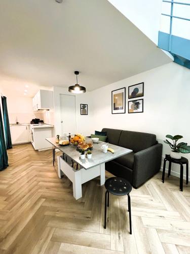 un salon avec une table et un canapé dans l'établissement La Maison Hugo, à Montreuil