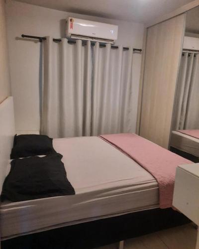um pequeno quarto com uma cama e uma janela em Segundo andar em Uberlândia