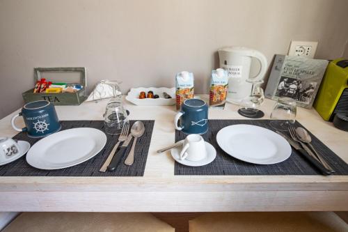 a table with white plates and utensils on it at Alla Marina Affittacamere in Riomaggiore