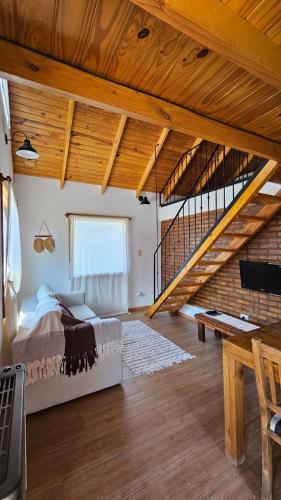 a bedroom with a bed and a wooden staircase at La casita suereña in Esquel