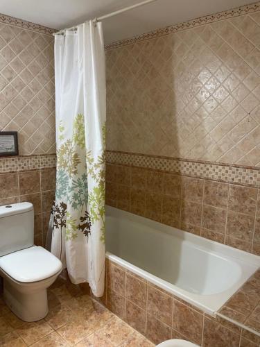 y baño con aseo y bañera. en Hotel Kaia en Ciérvana